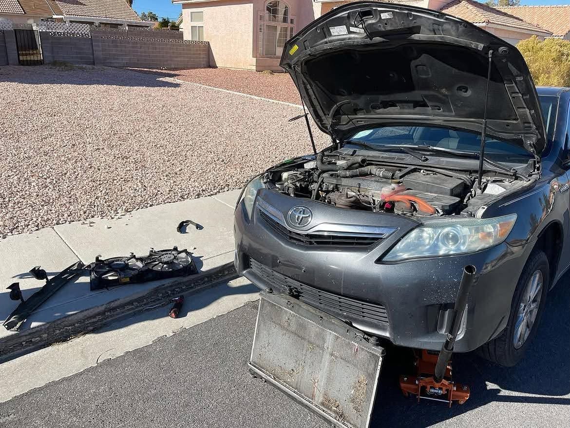 Toyota with its hood open and radiator and cooling components removed during repair