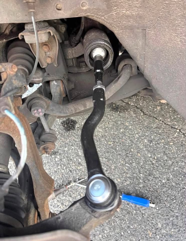 Close-up of a suspension and steering component being repaired