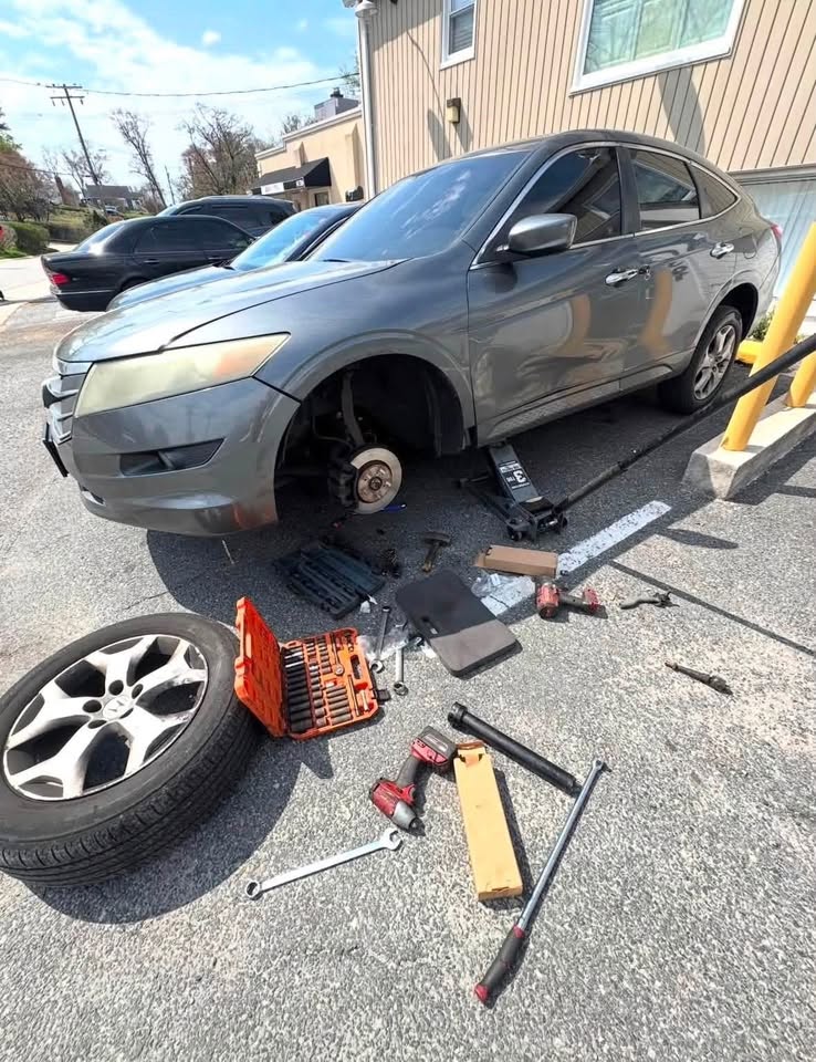 Dan performing hands-on repair on a vehicle with the wheel removed
